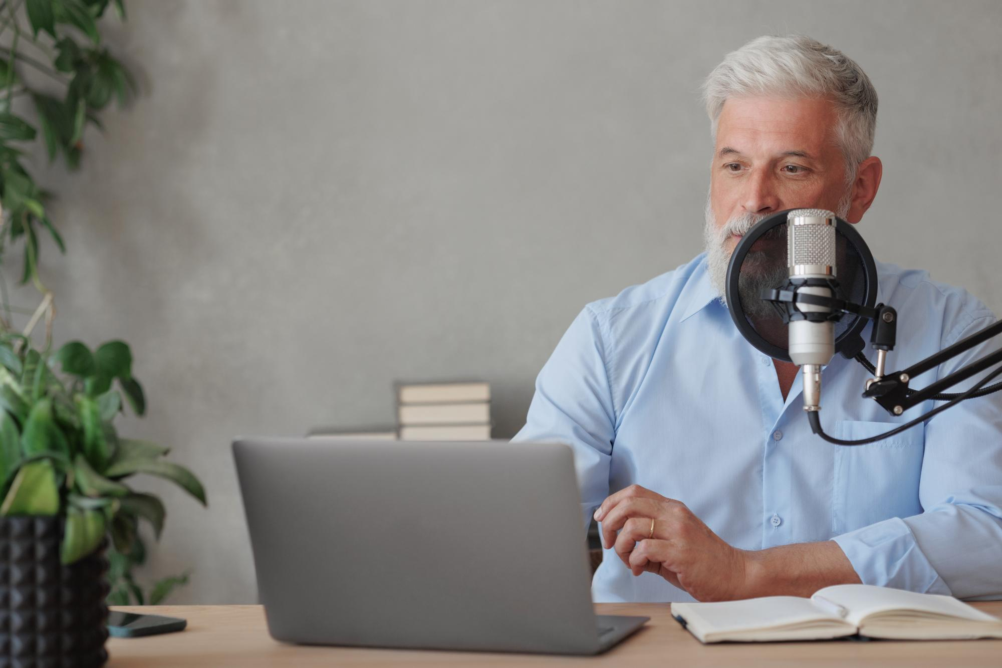 Médico sentado diante de um microfone, participando de um podcast para médicos.